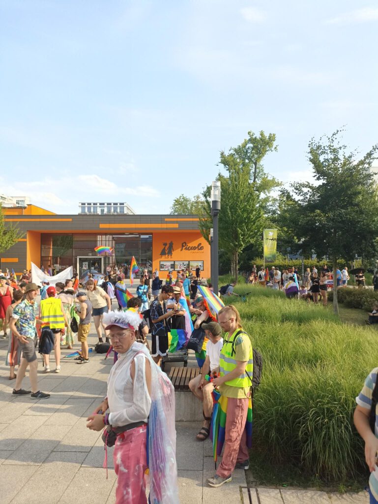 Beginn der Demo am Bahnhof. Ordner*innen in Reflektierenden Vesten sind zu sehen.